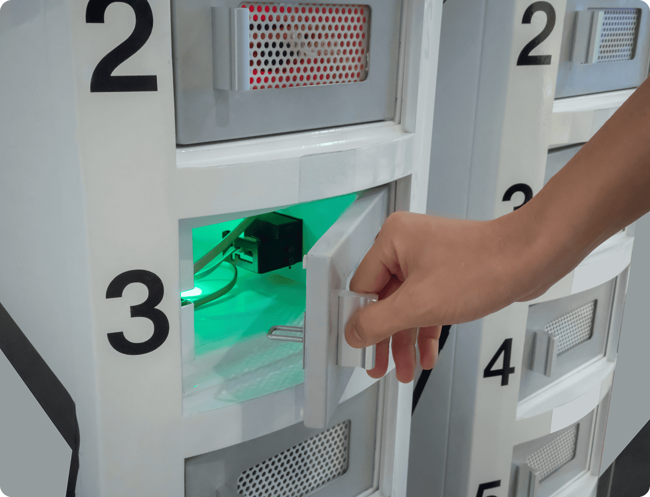 Hand opening a numbered electronic locker.