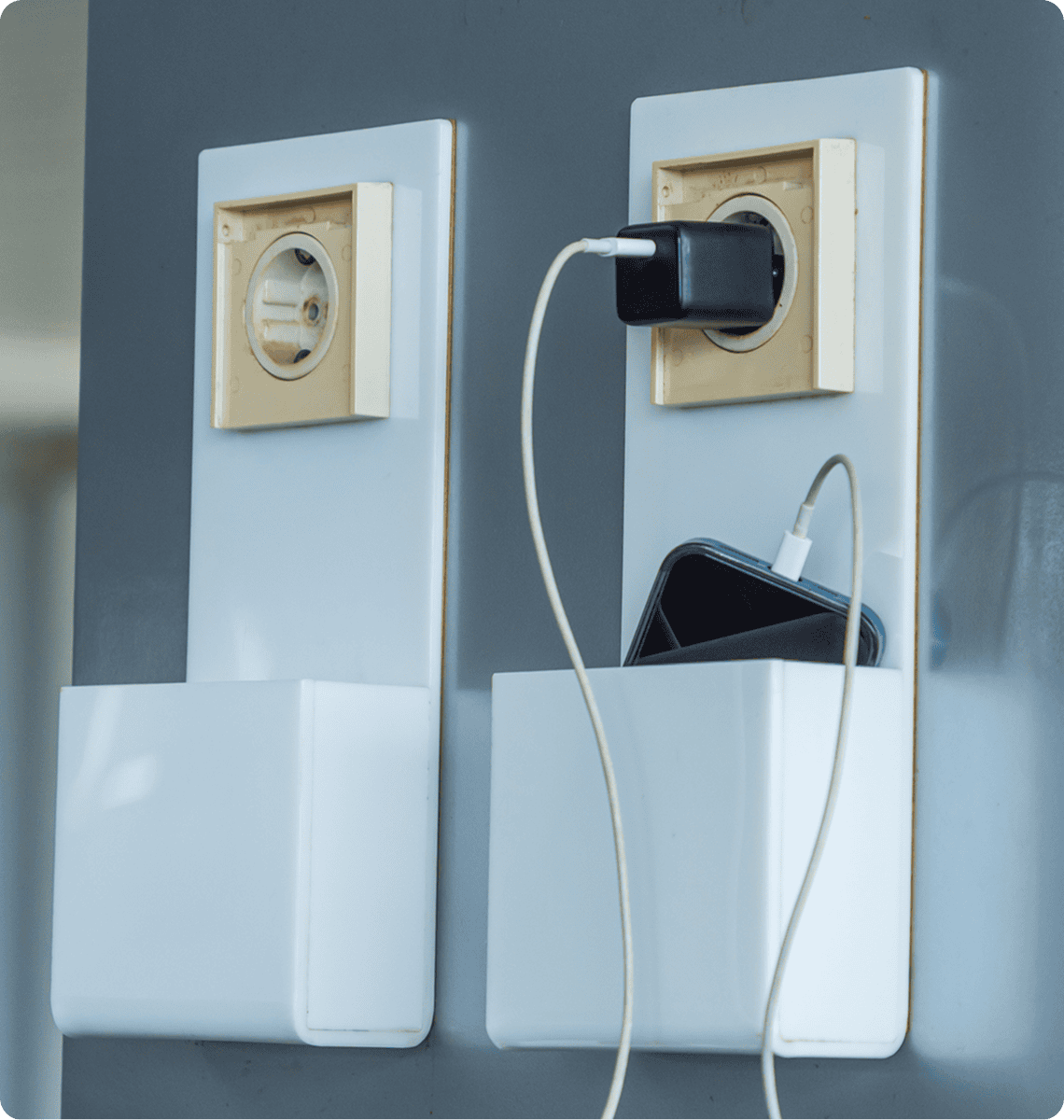 Phone charging in wall socket holder.